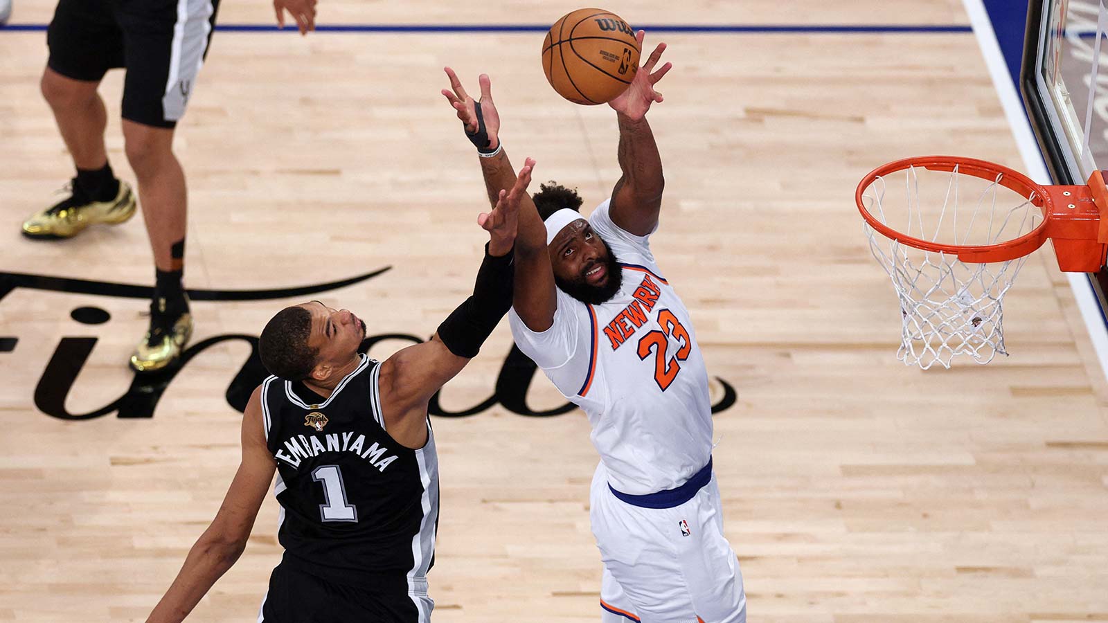 New York Knicks center Mitchell Robinson (23) jumps to catch a pass and dunk the ball against San Antonio Spurs forward Victor Wembanyama (1) during game four of the 2026 NBA Finals in the fourth quarter at Madison Square Garden.