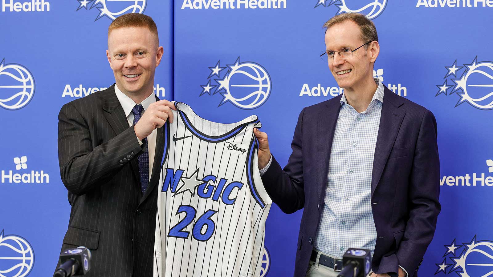 Orlando Magic President of Basketball Operations Jeff Weltman (right) presents new head coach Sean Sweeney with a number 26 jersey before a press conference at AdventHealth Training Center.