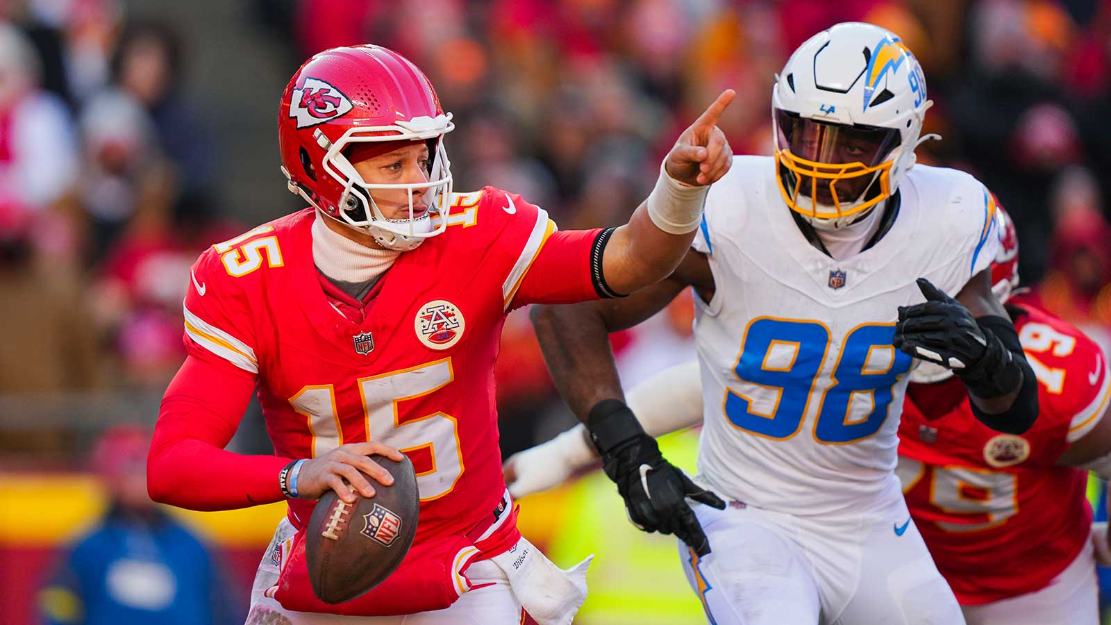 Kansas City Chiefs quarterback Patrick Mahomes (15) scrambles against Los Angeles Chargers linebacker Odafe Oweh (98) during the second half at GEHA Field at Arrowhead Stadium. 