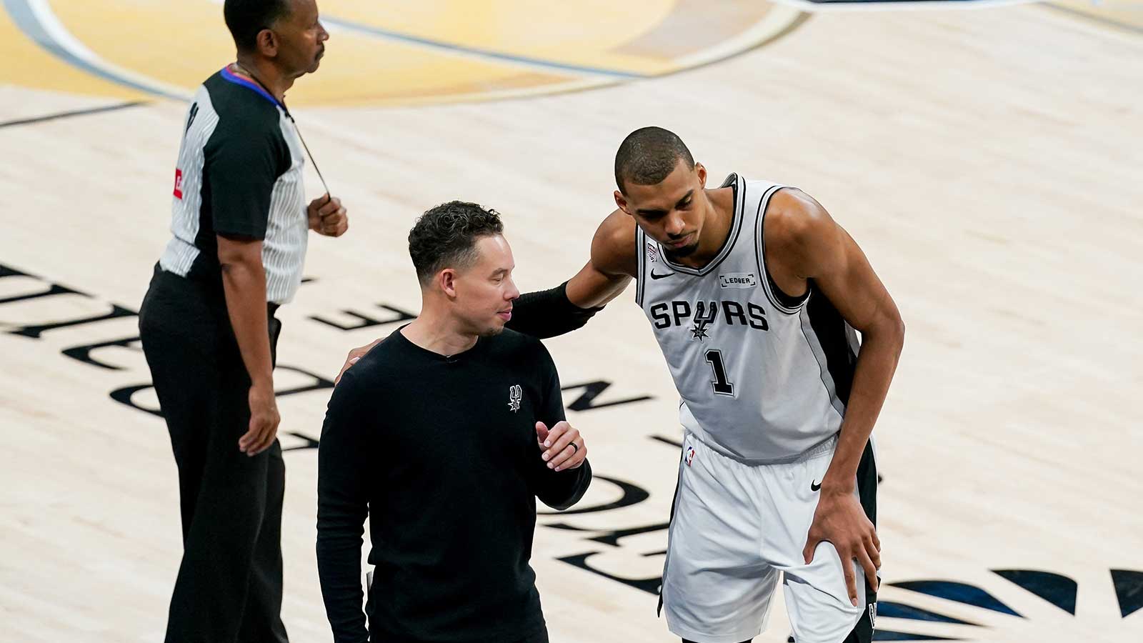 Spurs head coach Mitch Johnson talks with San Antonio Spurs forward Victor Wembanyama (1) against the New York Knicks in the second half during game five of the 2026 NBA Finals at Frost Bank Center