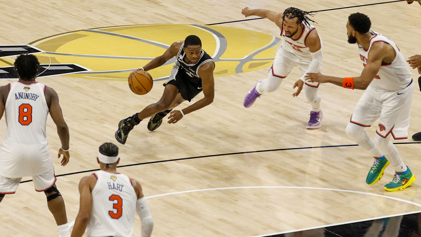 Spurs guard De'aaron Fox drives while surrounded by OG Anunoby, Josh Hart, Jalen Brunson, and Karl-Anthony Towns.