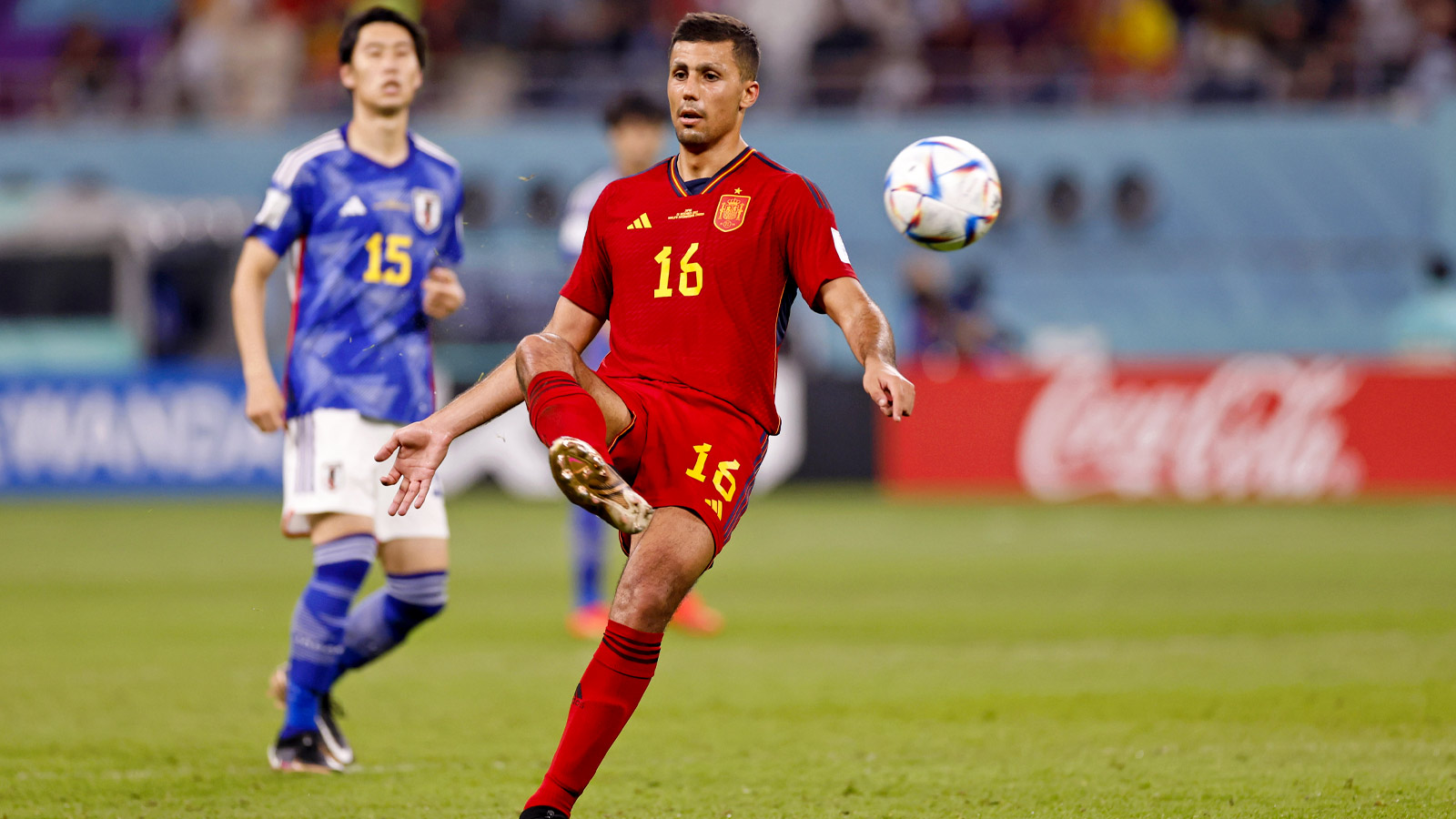 Spain midfielder Rodri (16) kicks the ball against Japan during the second half of a group stage match during the 2022 World Cup at Khalifa International Stadium.