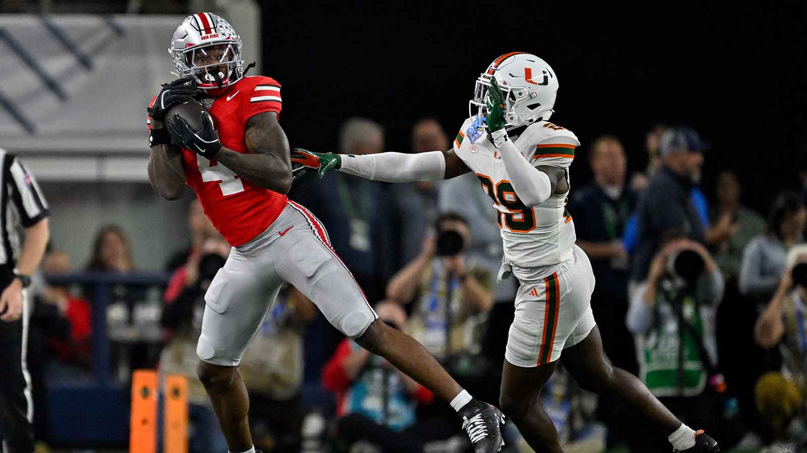 Ohio State Buckeyes wide receiver Jeremiah Smith (4) catches a pass in front of Miami Hurricanes defensive back OJ Frederique Jr. (29) during the 2025 Cotton Bowl and quarterfinal game of the College Football Playoff at AT&T Stadium.