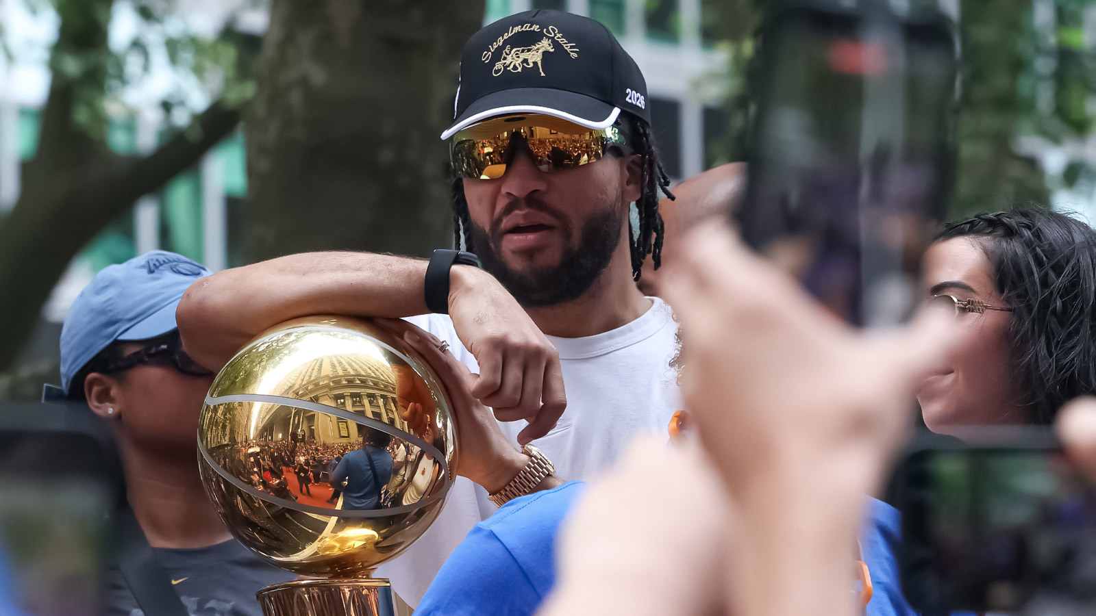 New York Knicks guard Jalen Brunson (11) celebrates while holding the Larry O'Brien Championship Trophy during the Knicks ticker-tape parade and celebration on Broadway in downtown Manhattan.