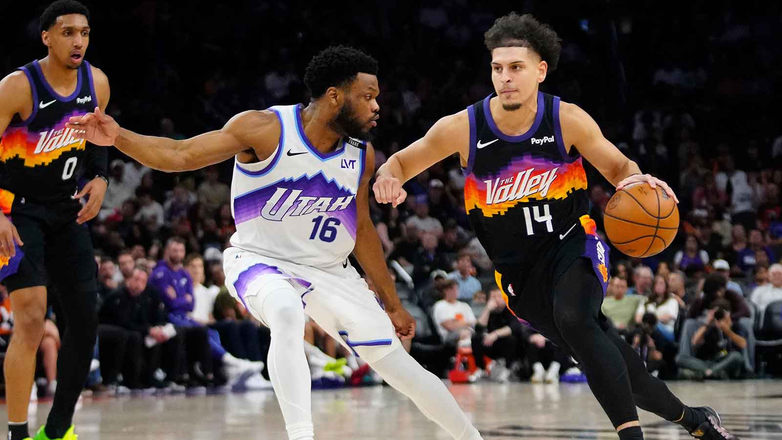 Suns guard Koby Brea (14) drives against Jazz guard Elijah Harkless (16) during a game at the Mortgage Matchup Center in Phoenix on March 28, 2026.