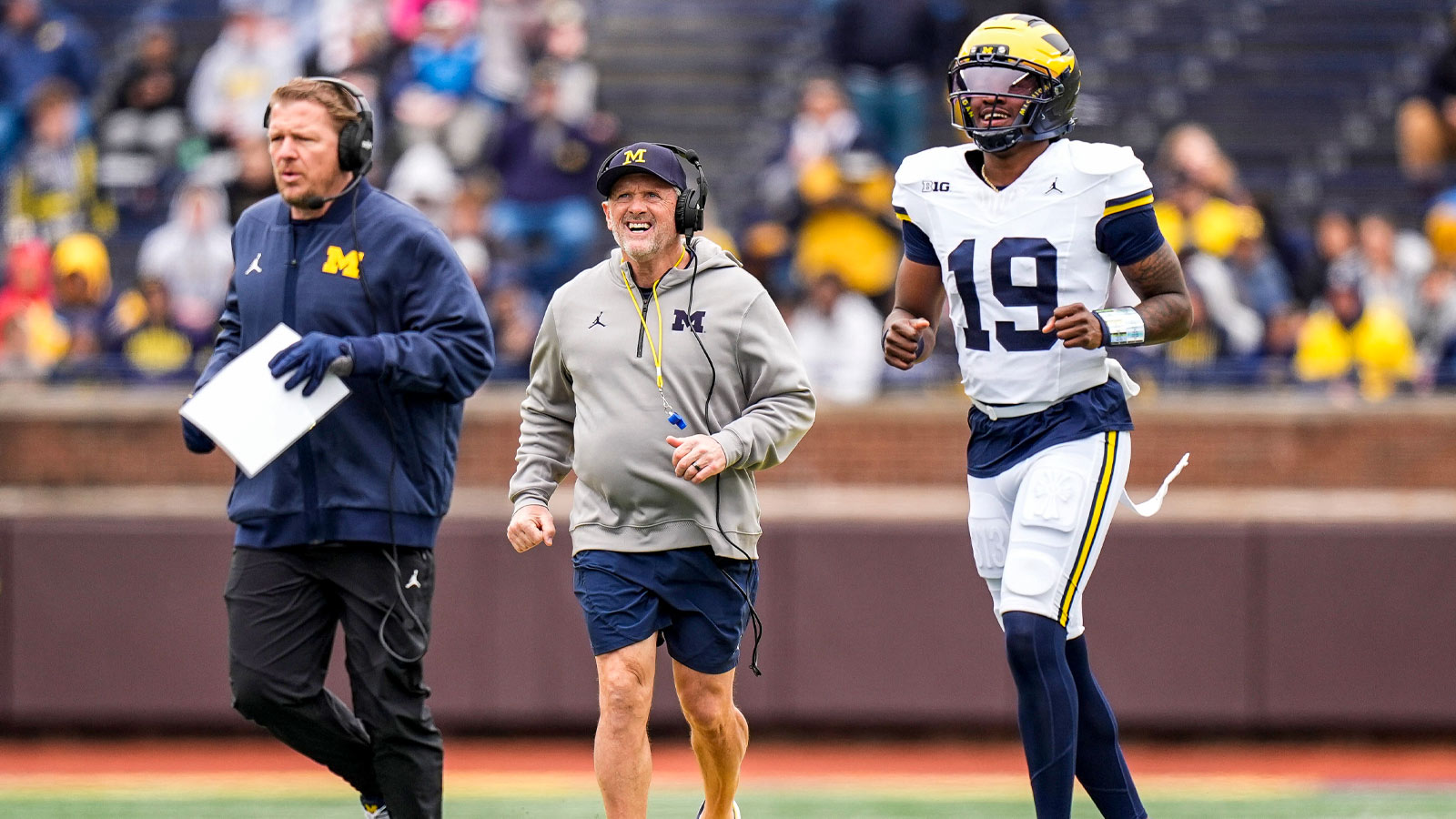 Michigan offensive coordinator Jason Beck, left, head coach Kyle Whittingham, center, and quarterback Bryce Underwood run across the field during the spring game at Michigan Stadium in Ann Arbor on Saturday, April 18, 2026.