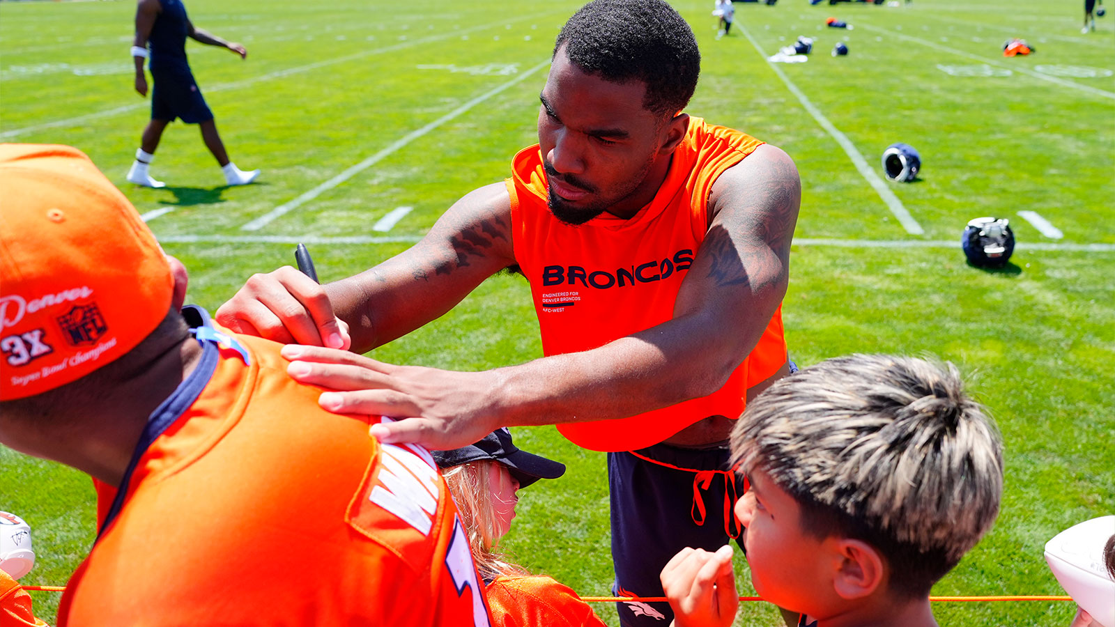 Denver Broncos wide receiver Jaylen Waddle (17) signs autographs following training camp at Broncos Park. 