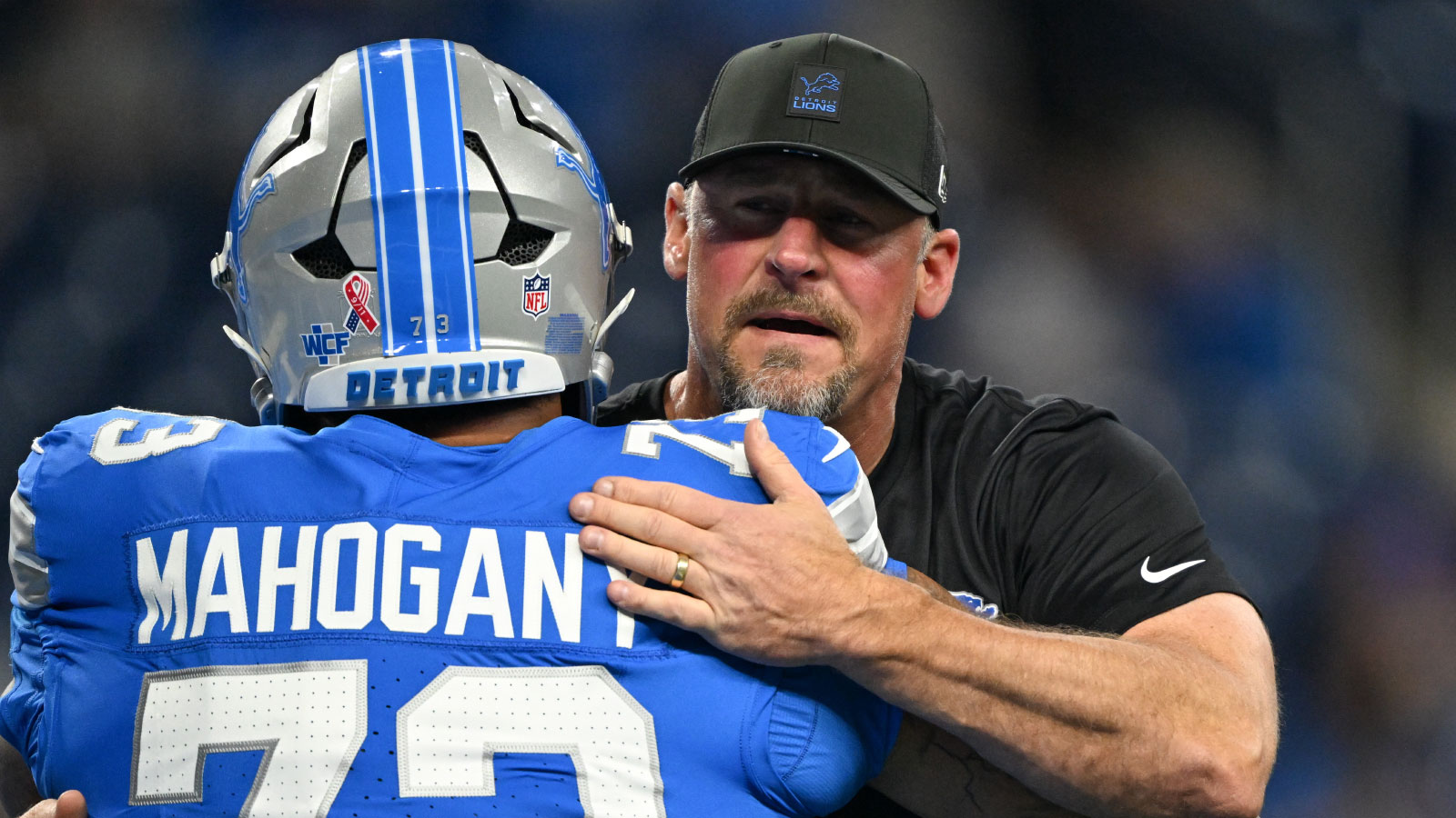 https://wp.clutchpoints.com/wp-content/uploads/2026/08/Lions-head-coach-Dan-Campbell-hugging-guard-Christian-Mahogany.jpg