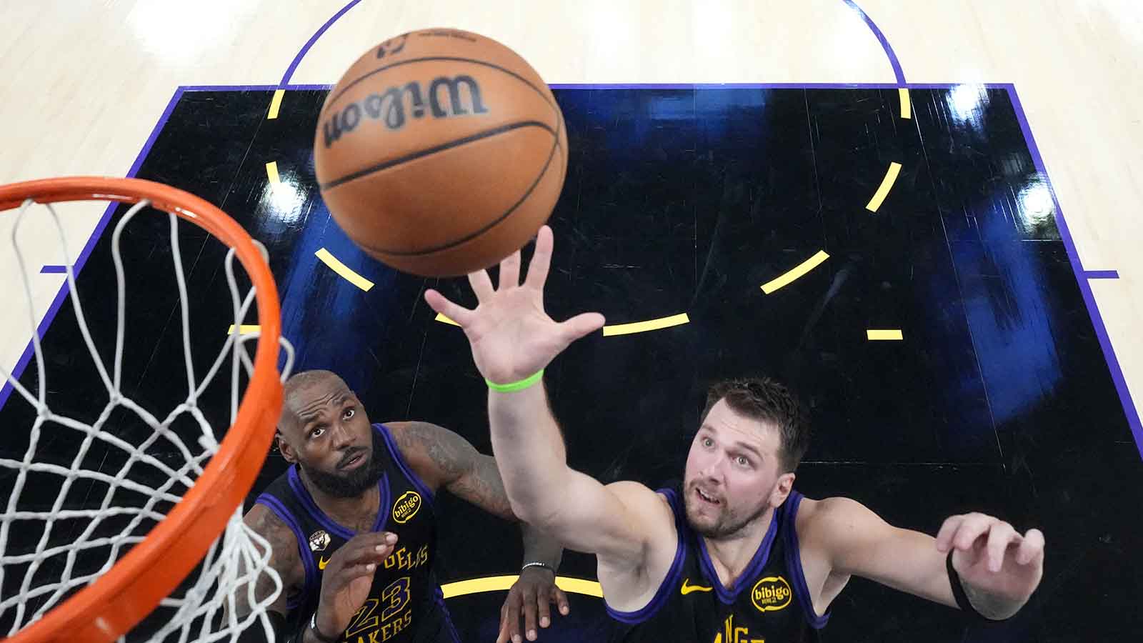 Los Angeles Lakers guard Luka Doncic (77) and forward LeBron James (23) rebound the ball against the New Orleans Pelicans in the second half at Crypto.com Arena.