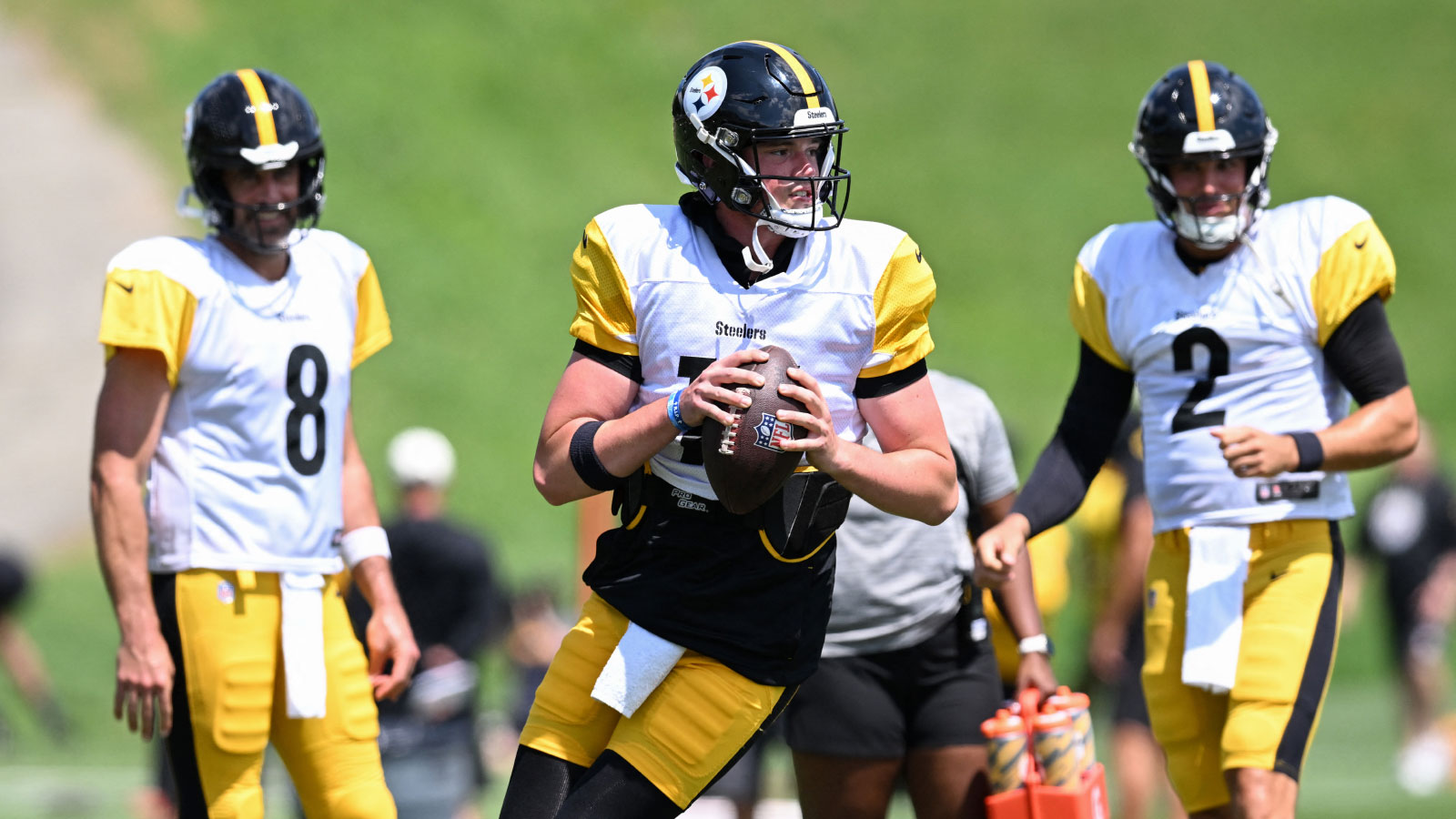 Pittsburgh Steelers quarterback Drew Allar (16) looks to pass as quarterbacks Aaron Rodgers (8) and Mason Rudolph (2) look on during a practice session at Training camp at Saint Vincent College.