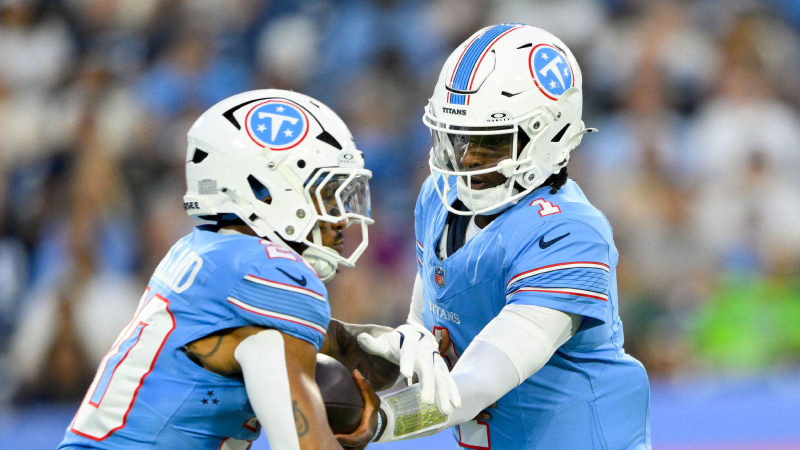 Tennessee Titans quarterback Cam Ward (1) hands the ball off to running back Tony Pollard (20) against the Seattle Seahawks during the first half at Nissan Stadium.