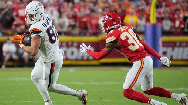 ; Denver Broncos tight end Adam Trautman (82) makes a catch against Kansas City Chiefs cornerback L'Jarius Sneed (38) at GEHA Field at Arrowhead Stadium.