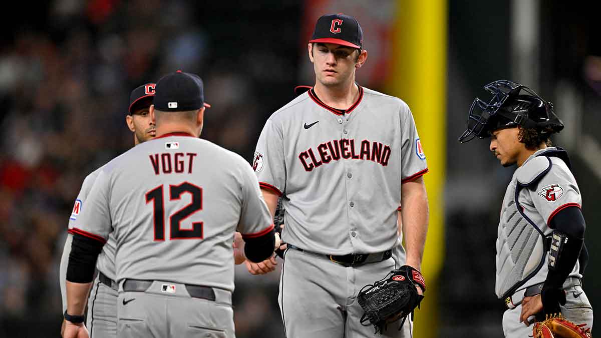 Cleveland Guardians manager Stephen Vogt (12) takes the ball from starting pitcher Gavin Williams (32) during the fourth inning at Globe Life Field.