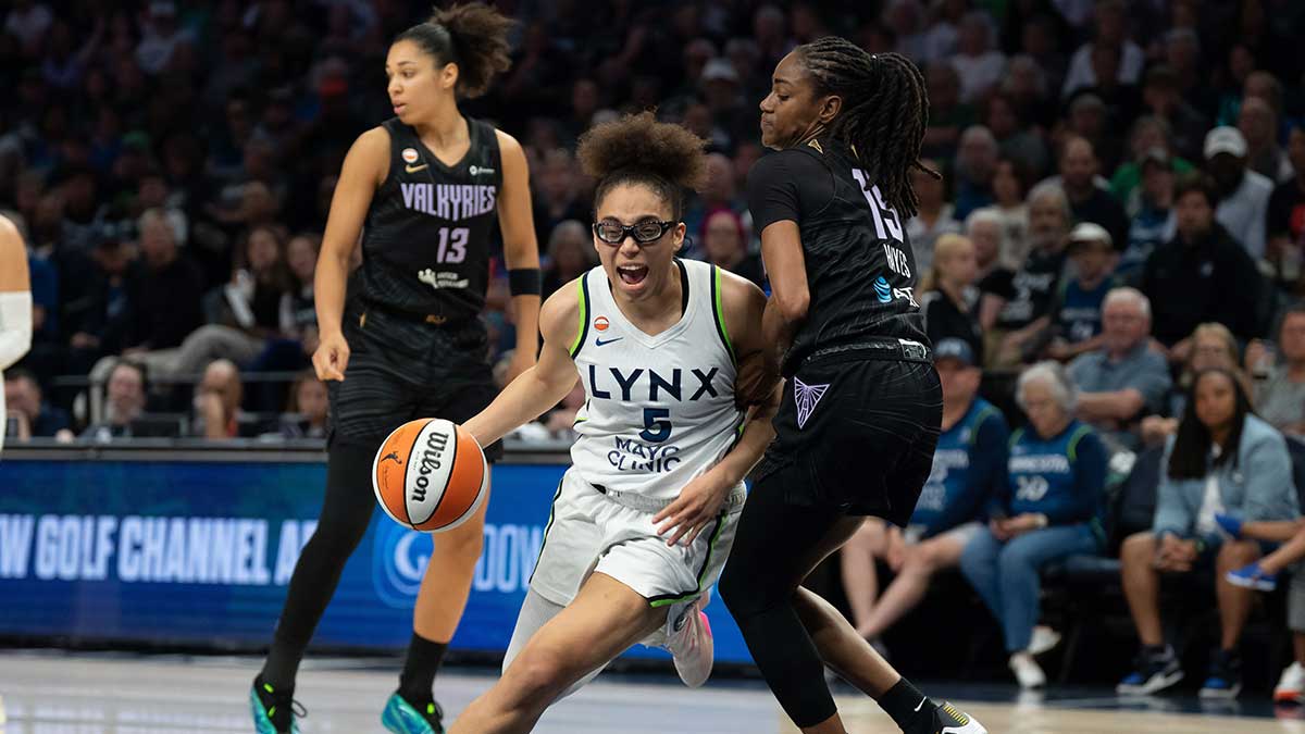 Minnesota Lynx guard Olivia Miles (5) dribbles the ball past Golden State Valkyries guard Tiffany Hayes (15) in the second half at Target Center.