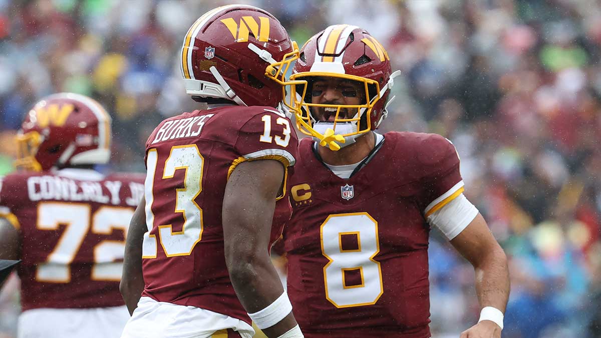 Washington Commanders quarterback Marcus Mariota (8) reacts with wide receiver Treylon Burks (13) in the first half at Northwest Stadium. Mandatory Credit: Geoff Burke-Imagn Images