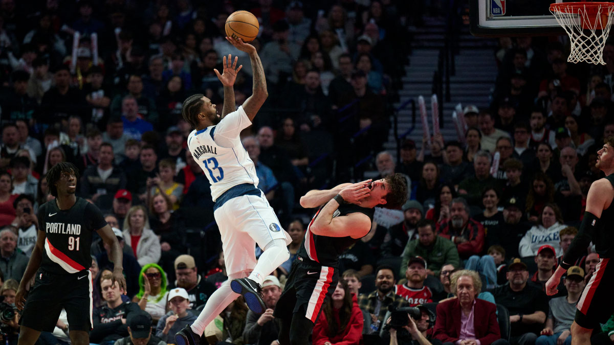 Dallas Mavericks forward Naji Marshall (13) shoots a basket during the first half against Portland Trail Blazers forward Deni Avdija (8) at Moda Center. 