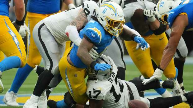 Las Vegas Raiders linebacker Nakobe Dean (17) forces a fumble against Los Angeles Chargers running back Omarion Hampton (8) during the second half at SoFi Stadium.