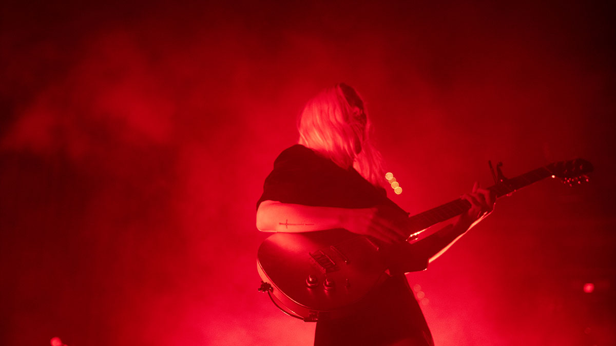 Phoebe Bridgers playing guitar.