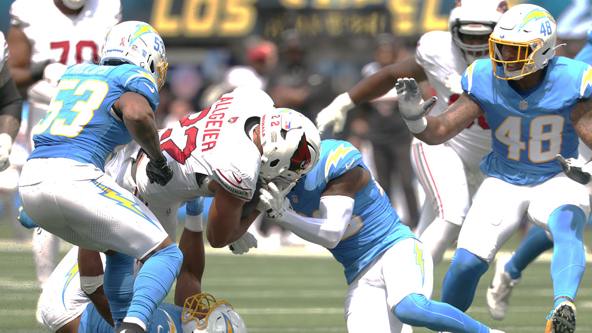 Sep 13, 2026; Inglewood, California, USA; Arizona Cardinals running back Tyler Allgeier (22) is tackled by a host of Los Angeles Chargers during the first quarter at SoFi Stadium.