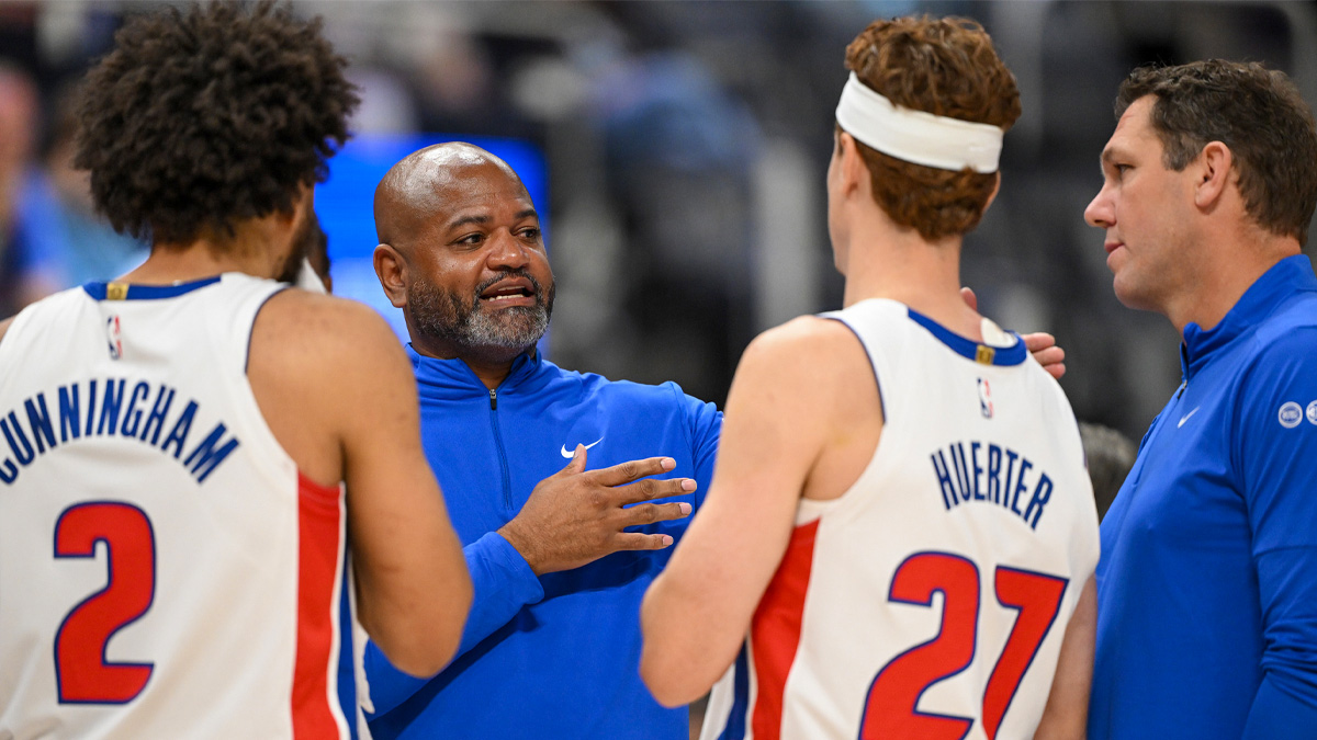 Detroit Pistons head coach J.B. Bickerstaff talks with players Cade Cunningham (2) and Kevin Huerter (27) during a timeout against the Phoenix Suns in the first quarter at Little Caesars Arena.