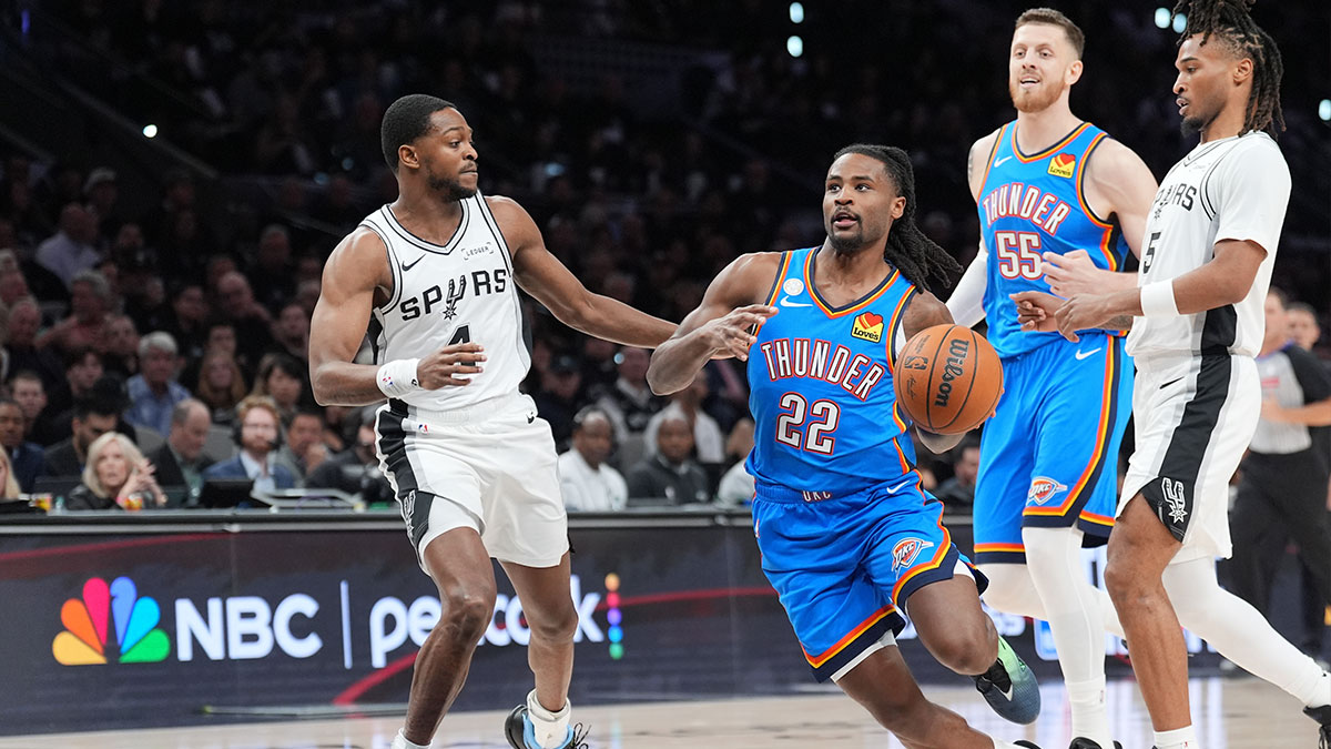 Oklahoma City Thunder guard Cason Wallace (22) controls the ball against San Antonio Spurs guard De'aaron Fox (4) in the second half at Frost Bank Center.