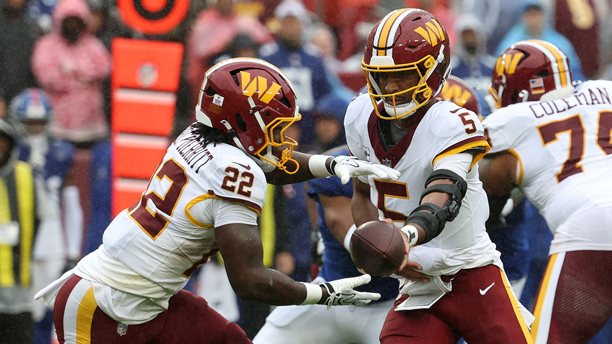 Washington Commanders quarterback Jayden Daniels (5) hands the ball off to Commanders running back Jacory Croskey-Merritt (22) against the New York Giants at Northwest Stadium.