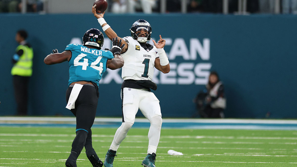Philadelphia Eagles quarterback Jalen Hurts (1) throws a pass as Jacksonville Jaguars defensive end Travon Walker (44) defends during the fourth quarter at Tottenham Hotspur Stadium.