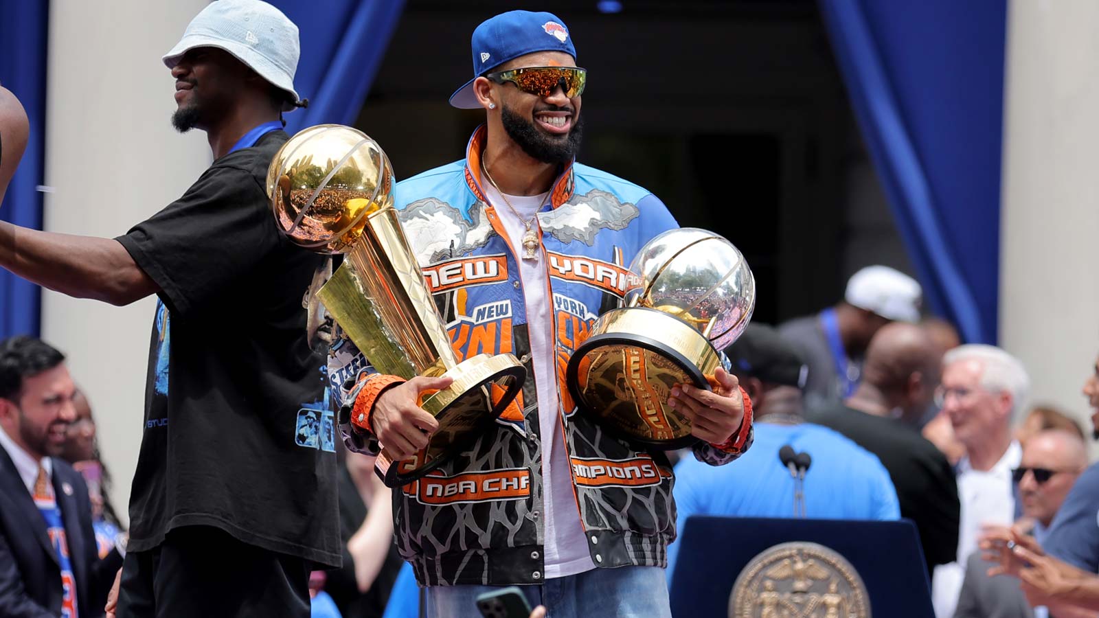 New York Knicks center Karl-Anthony Towns celebrates with the Larry O'Brien championship trophy and the eastern conference finals trophy during a ceremony at New York City Hall after the championship parade.
