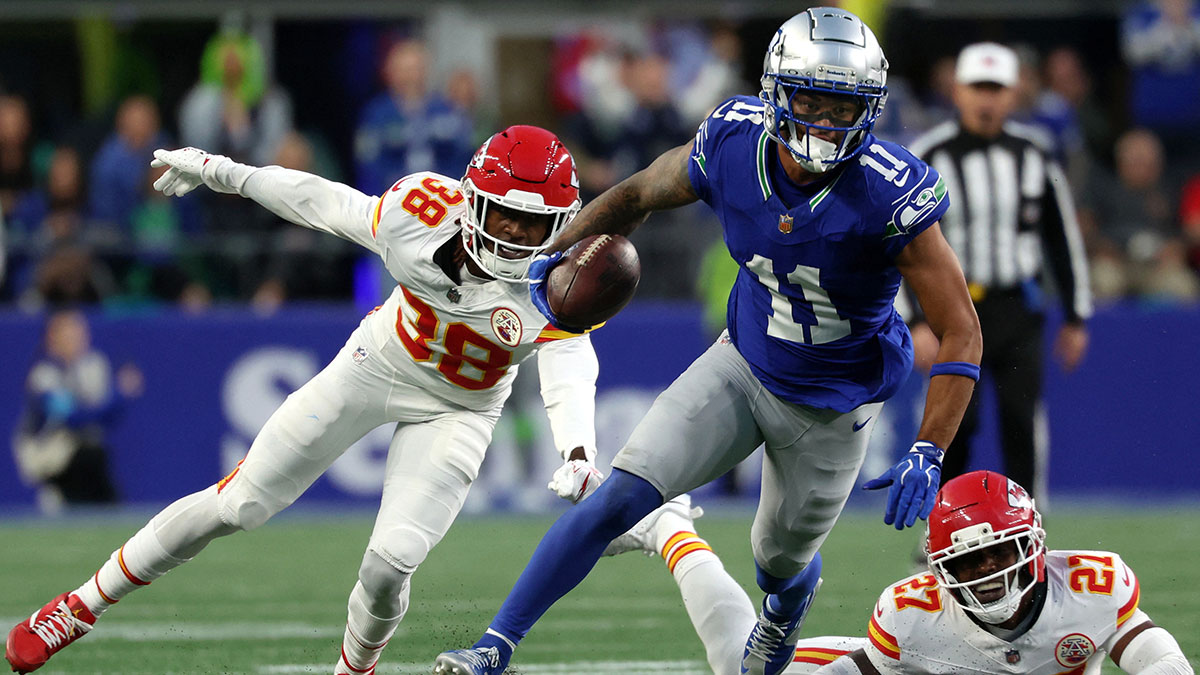 Seattle Seahawks wide receiver Jaxon Smith-Njigba (11) avoids a tackle by Kansas City Chiefs defensive back Chamarri Conner (27) and cornerback L'Jarius Sneed (38) during the second quarter at Lumen Field.